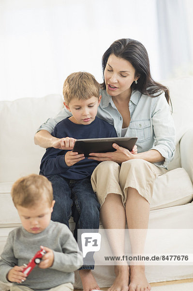 Mother and sons (12-17 months  6-7) with tablet pc
