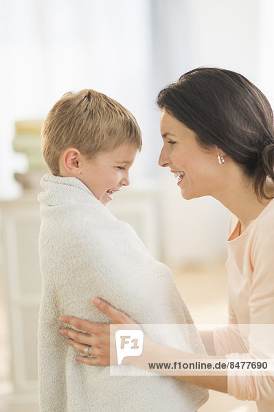 Mother with son (6-7) wrapped in towel