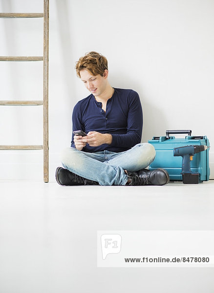 Man with toolbox using phone