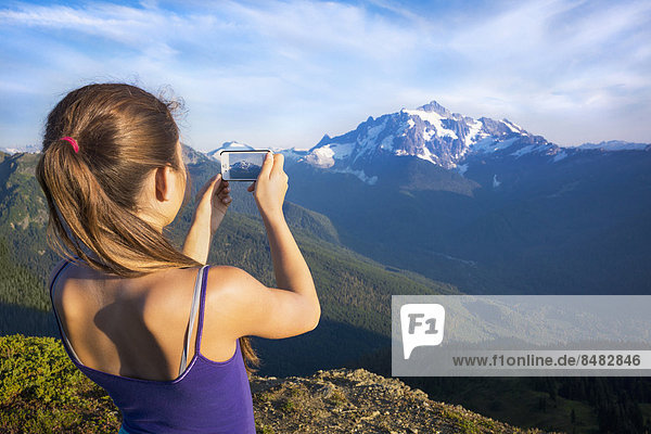 Mixed race girl photographing mountains  North Cascade Mountains  Washington  United States