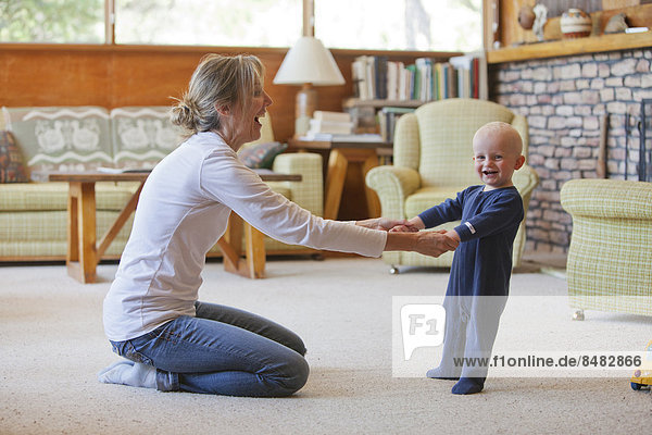 Caucasian mother and baby playing in living room