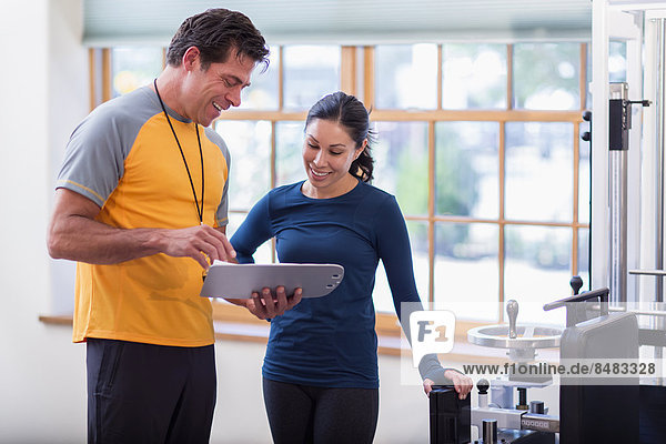 Woman working with personal trainer in gym