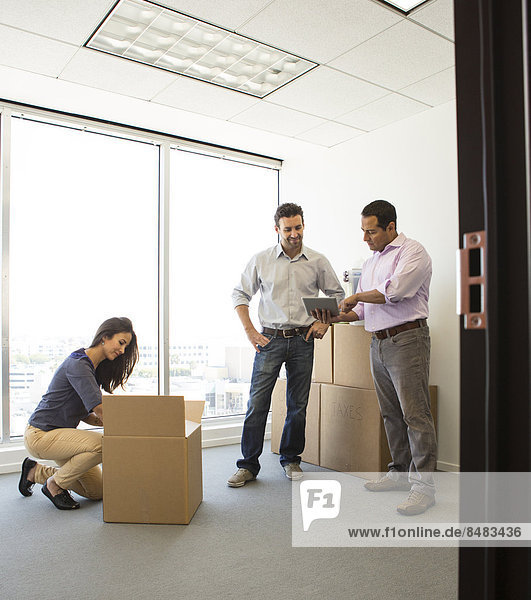 Business people unpacking in new office