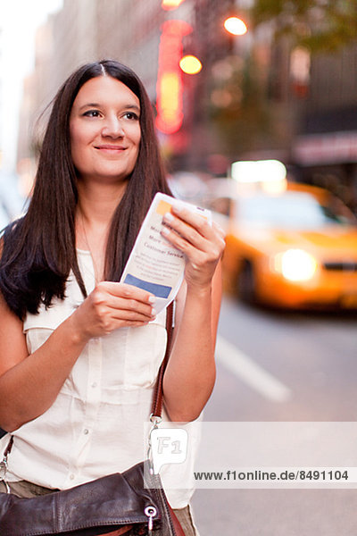 Smiling woman holding leaflet  New York City  USA