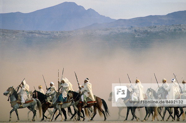 Moroccan horsemen riding in an equestrian Fantasia in Morocco.