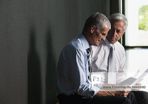 Zwei Businessmänner im Gespräch  dunkler Hintergrund