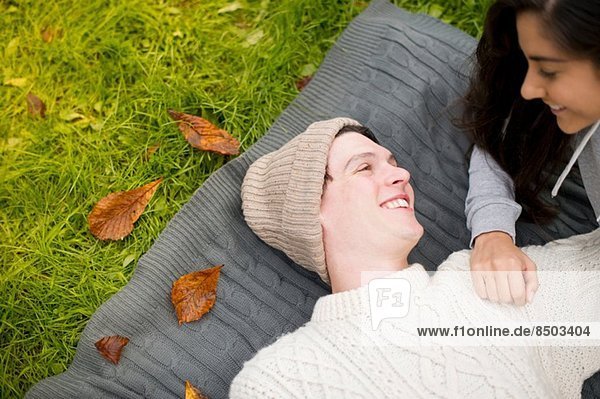 Young couple lying on rug  man wearing knit hat