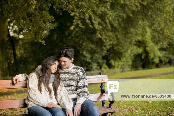 Junges Paar auf Parkbank sitzend
