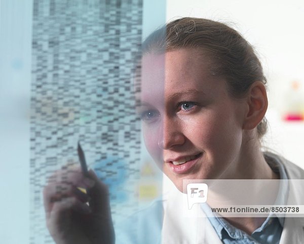 Forscherin untersucht DNA-Autoradiogramm-Gel im Labor