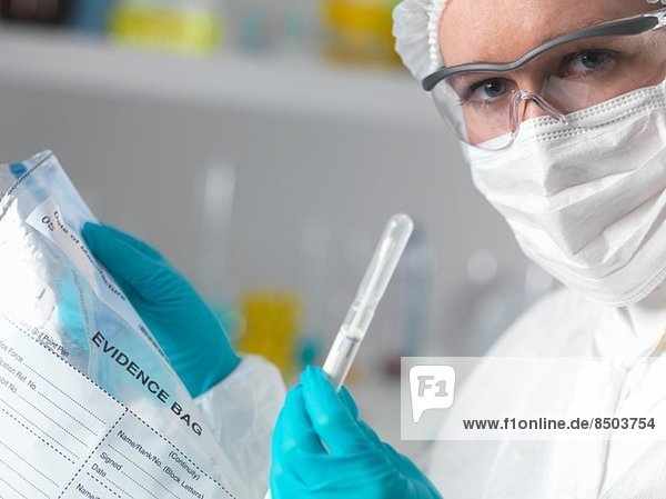 Kriminaltechniker im Labor mit Beweismittelbeutel und Tupfer zur Verbrechensbekämpfung