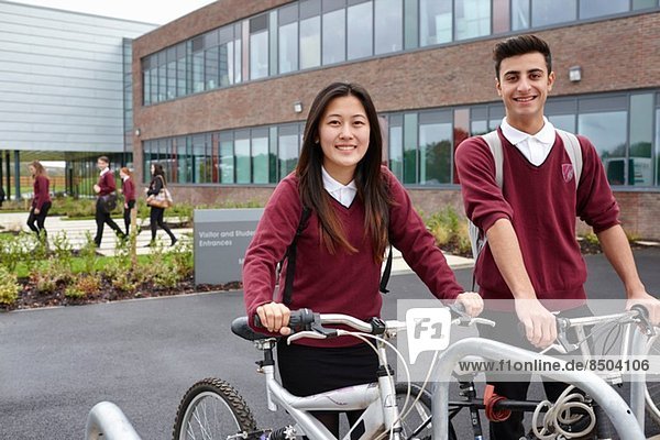 Teenager friends with cycles outside school