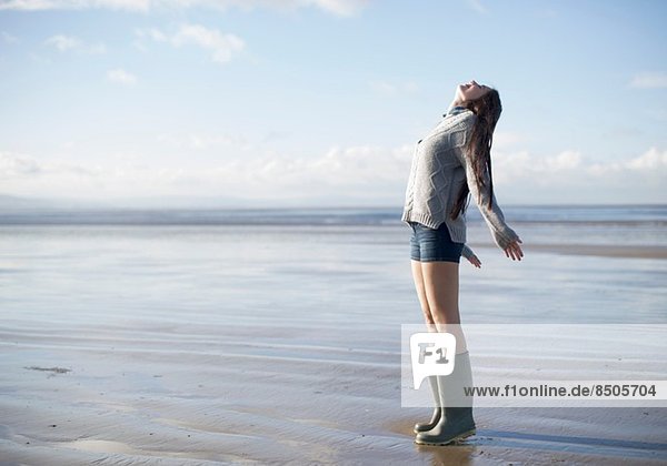 Young woman standing on beach looking up  Brean Sands  Somerset  England