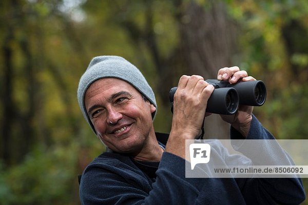Mature man holding binoculars