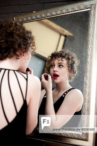 Porträt einer jungen Frau mit Lippenstift im Spiegel