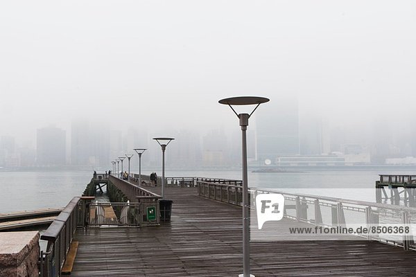 East river pier and skyline in mist  New York City  USA