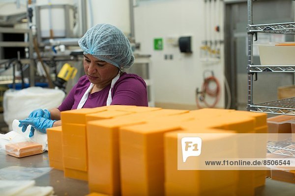 Frau verpackt veganen Käse im Lagerhaus