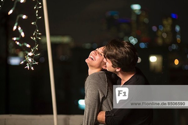 Young couple embracing at rooftop party
