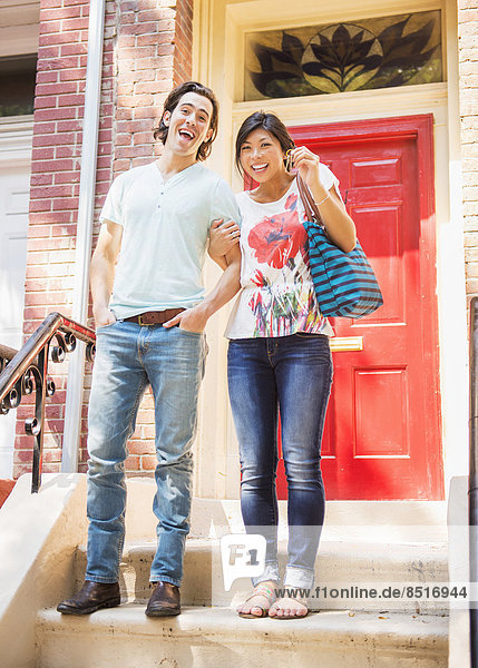 Couple standing on front stoop with house key