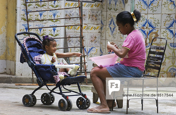 Frau mit einem Kind in einem Hof  Havanna  Kuba