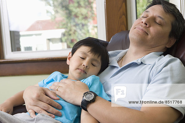 Hispanic father and son napping