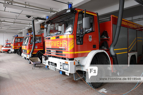 Feuerwehrfahrzeuge in einer Feuerwehrwache.