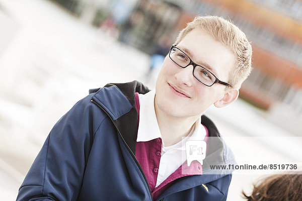 Smiling young man with glasses outdoors