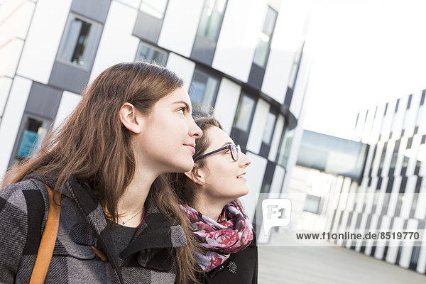 Two students outdoors looking up