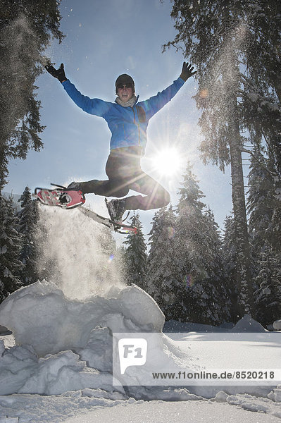 Austria  Salzburg State  Altenmarkt-Zauchensee  Man with snowshoes jumping in winter landscape