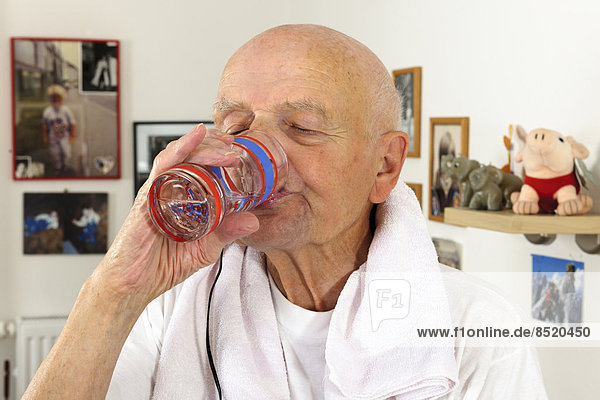 Portrait of old man drinking water