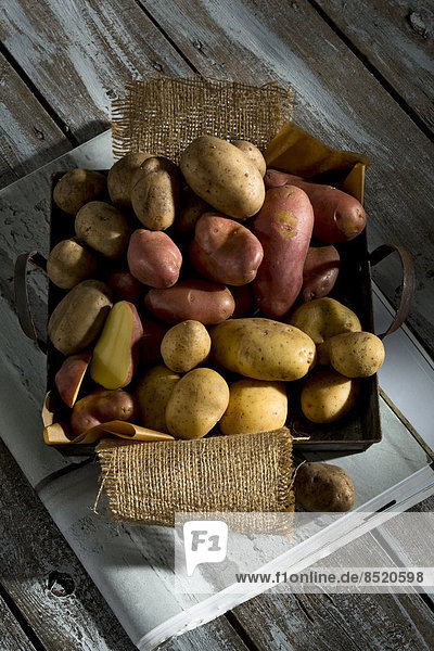 Different sorts of organic potatoes on metal tray