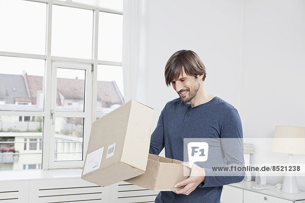 Mann beim Auspacken des Kartons
