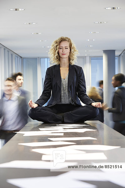 Business woman meditating on desk