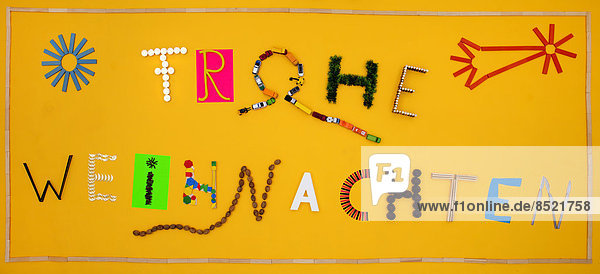 '''Frohe Weihnachten'' formed of letters builded with different materials'