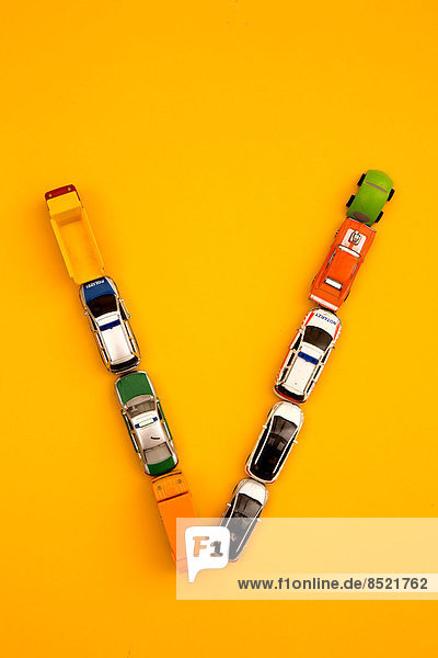 'Letter ''ß'' formed of toy cars at yellow background  studio shot'