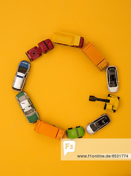 'Letter ''O'' formed of toy cars at yellow background  studio shot'
