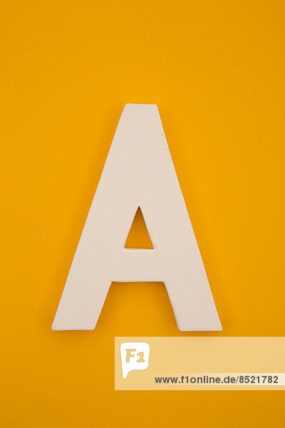 'White letter ''A'' formed at yellow background  studio shot'