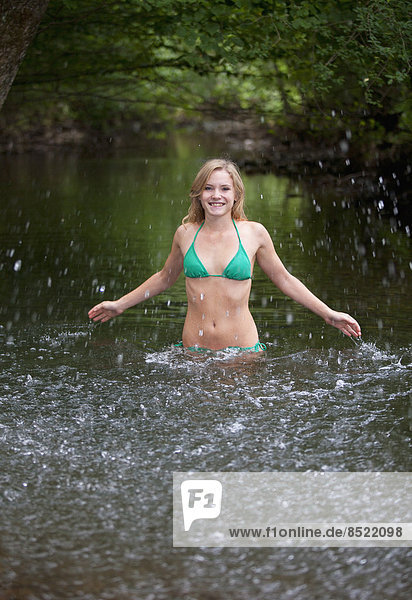 Austria  Salzkammergut  Mondsee  young woman bathing in a brook