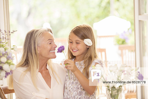 Großmutter und Enkelin riechende Blumen