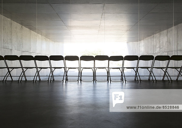 Silhouette von Bürostühlen in einer Reihe aufgestellt