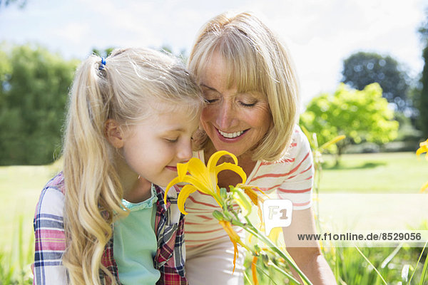 Grandmother and granddaughter smelling flowers