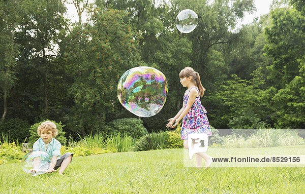 Children playing with bubbles in backyard