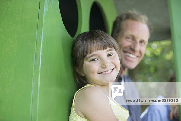 Vater und Tochter lächeln im Baumhaus