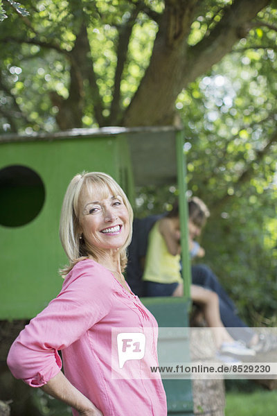 Woman smiling with treehouse in background