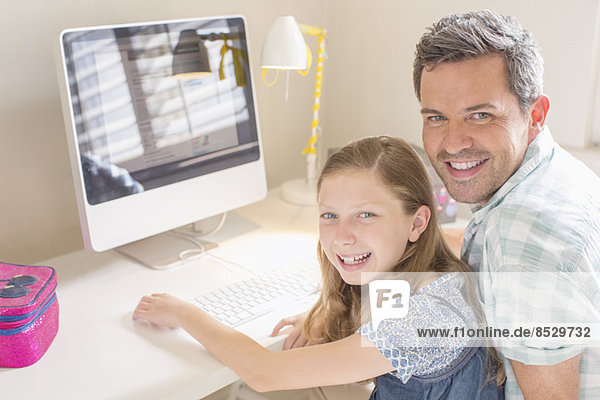 Vater und Tochter nutzen gemeinsam den Computer
