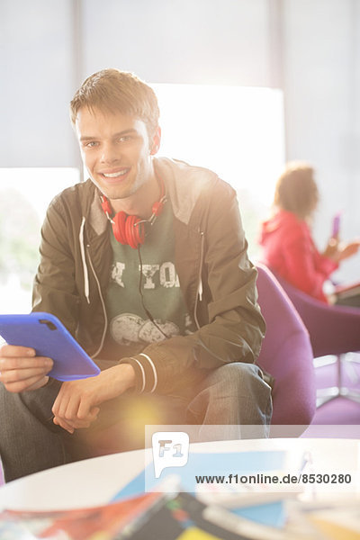 Universitätsstudent mit digitalem Tablett in der Lounge