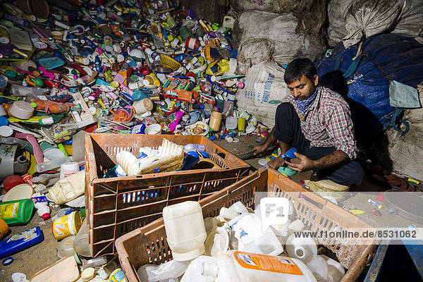 Ein Arbeiter sortiert Plastikmüll zum Recycling  Dharavi Slum  ??Mumbai  Maharashtra  Indien