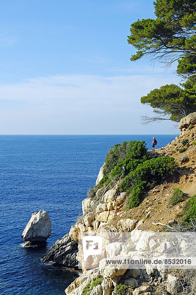 Woman hiking on the cliffs  near Deia  Sierra de Tramuntana  Majorca  Balearic Islands  Mediterranean  Spain