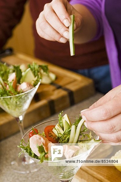 Preparing Individual Salads with Tuna and Cucumber Sticks