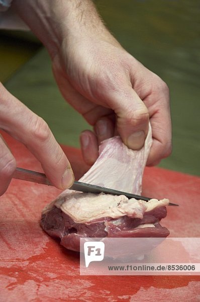 The skin being removed from a piece of meat