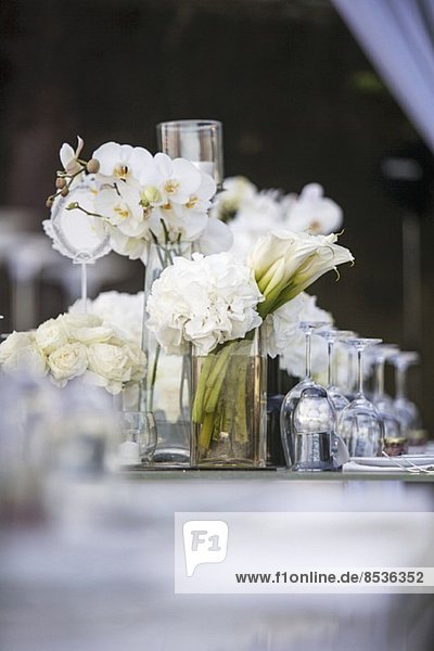 Weisse Rosen  Hortensien und Orchideen als festliche Tischdeko